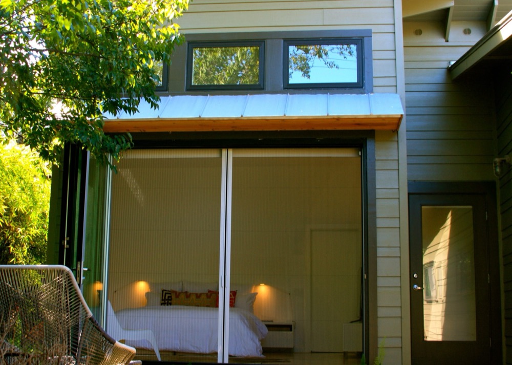 Pleated screen across a wide sliding opening onto a bedroom