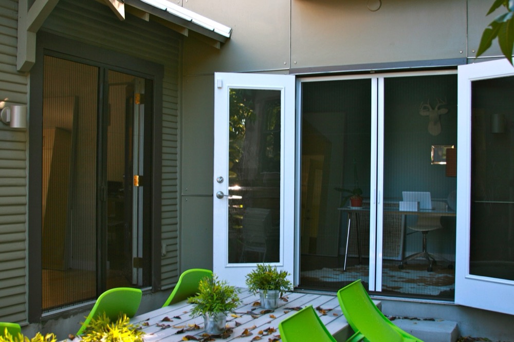Wide multi-panel opening onto a patio, screens fitted