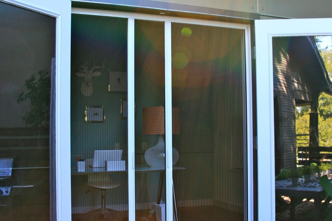 Sunlight through a pleated screen on a glass door