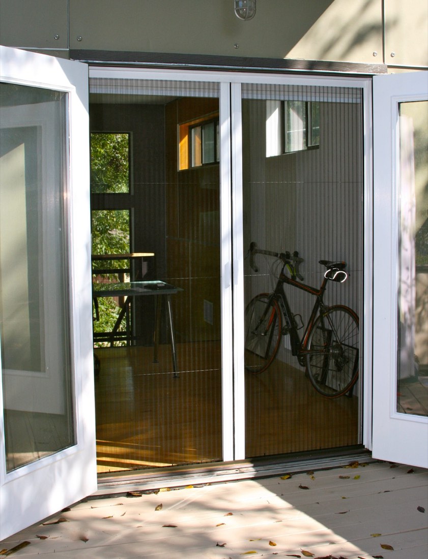 French door standing open with the pleated screen retracted to the side