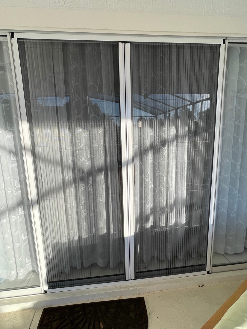 Pleated screen fully closed across a double door